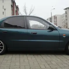Zielony Lanos z przyciemnianymi szybami i srebrnymi felgami wieloramiennymi.