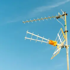 Antena telewizyjna z żółtym wzmacniaczem na maszcie, gotowa do podłączenia.