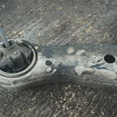 Zużyty silentblock, czyli element gumowo-metalowy, w wahaczu samochodowym.