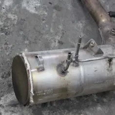 Element układu wydechowego, prawdopodobnie co to dpf, z metalowymi rurkami i oznaczeniami.
