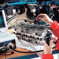 Mechanik bada głowicę silnika za pomocą endoskopu. Ekran pokazuje wnętrze cylindra, co pomaga zrozumieć, co oznacza TDI w kontekście silników.