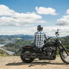 Motocyklista na czarnym Harley-Davidsonie podziwia krajobraz. To dobry motor szosowo turystyczny na wyprawę.