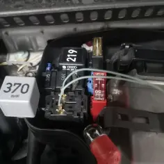 Szukasz przekaźnika świec żarowych 1.9 TDI? Na zdjęciu widać moduł z przekaźnikami i bezpiecznikami, gdzie może znajdować się ten element.