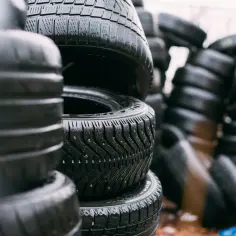 Stosy opon samochodowych, niektóre z kolcami, na zewnątrz.