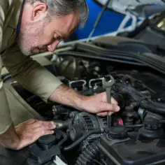 Mechanik sprawdza silnik, szukając objawów uszkodzonych świec żarowych.