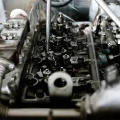 Widok z góry na rozebrany silnik, słychać stukanie na zimnym silniku. Widać zawory, wtryskiwacze i inne elementy mechaniczne.