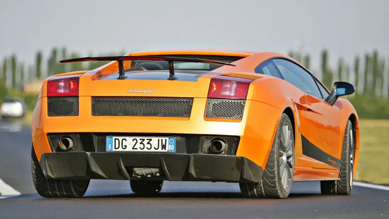 Pomarańczowe Lamborghini Gallardo z dużym spojlerem. Zastanawiasz się, ile kosztuje lamborghini gallardo?