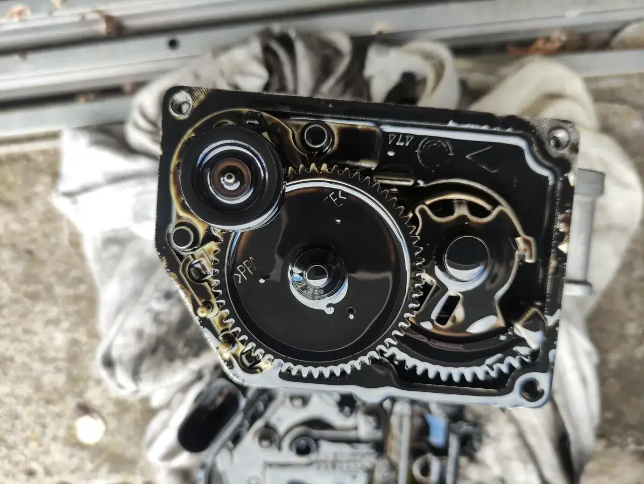 Widoczne zębatki i mechanizm klapy gaszącej, pokryte olejem. Mogą to być objawy uszkodzonej klapy gaszącej.
