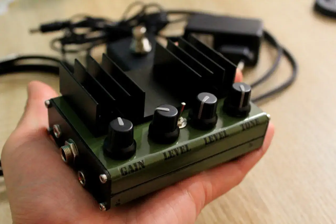 Ręcznie wykonany schemat wzmacniacza audio 12v w zielonej obudowie z gałkami Gain, Level i Tone.