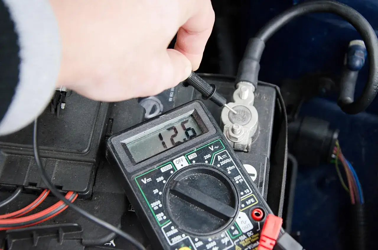 Multimetr pokazuje 12.6V, sprawdzając ile volt ma akumulator.