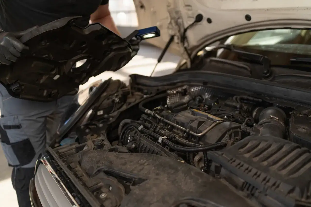 Mechanik sprawdza silnik benzynowy, który zaczął niepokojąco klekotać.