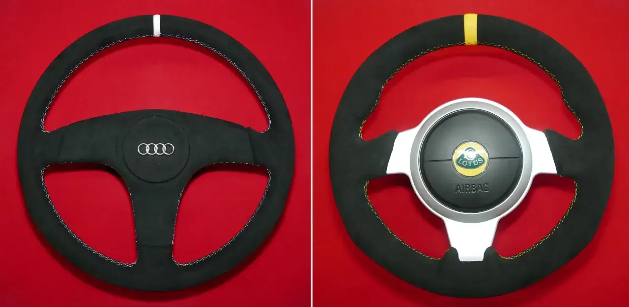 Kierownica Audi i Lotus, czarna z przeszyciami. Zastanawiasz się, ile kosztuje obszycie kierownicy?