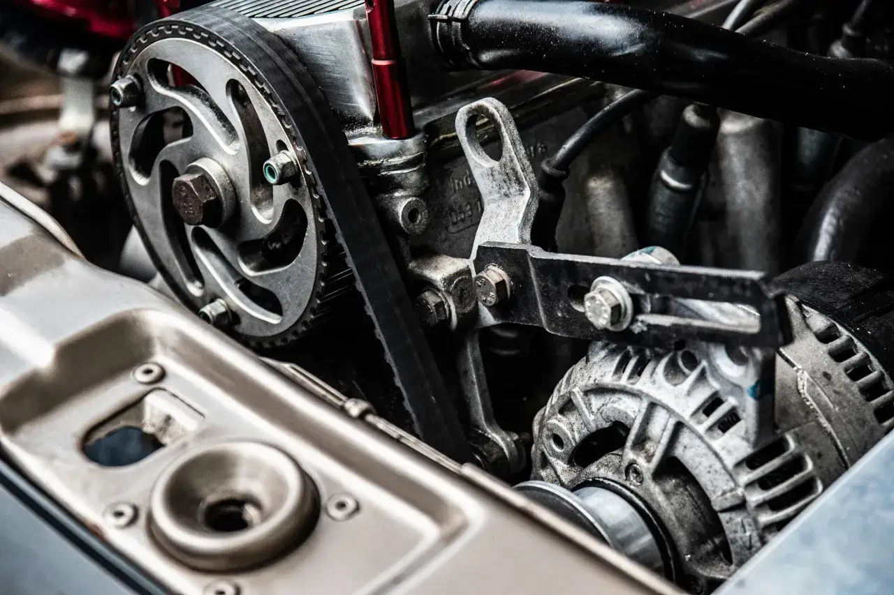 Silnik samochodowy z paskiem napędowym i alternatorem. Czy alternator ładuje akumulator na postoju? To pytanie, na które odpowiedź daje diagnostyka.